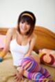 Pui seated on bed wearing white top