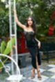 Wearing long black dress legs crossed in high heels