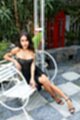 Sitting on white bench wearing dress in high heels