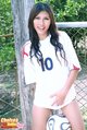 Standing against wire fence wearing football shirt