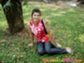 Seated on grass under tree flashing vee sign